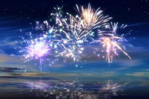 beau feu d'artifice de bonne année dans le ciel avec des reflets sur l'eau photo