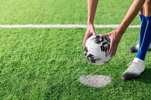 joueur de football ou de football professionnel donne un coup de pied et tire le ballon au penalty ou coup franc au gardien de but pour avoir remporté le but du champion dans la ligue de match final dans le stade de terrain photo