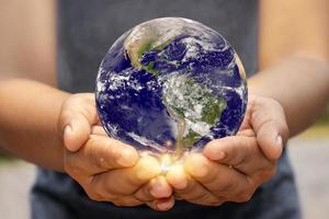 le monde est tenu par des mains humaines sur le concept du jour de la terre le 22 avril de chaque année pour économiser de l'énergie. photo