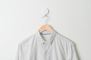 chemise suspendue avec cintre en bois au mur