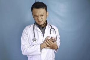 un portrait d'un jeune médecin asiatique a l'air douloureux sur sa poitrine photo