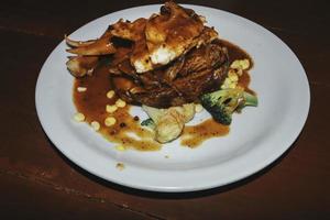 une assiette de steak de poulet et de boeuf et des saucisses photo