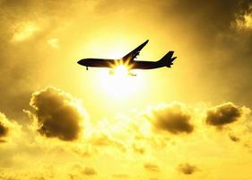 avion silhouette dans le ciel chaud et léger avec la lumière du soleil par derrière photo