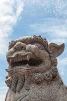 lion de pierre chinois sur fond de ciel bleu photo