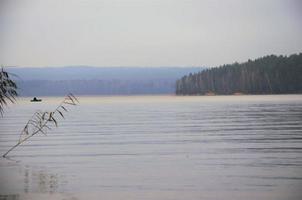 paysage calme, bord de lac au loin bateau photo