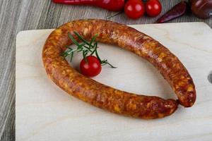 anneau de saucisse sur plaque de bois et fond de bois photo