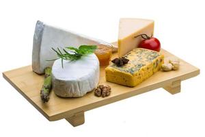 assortiment de fromages variés sur plaque de bois photo