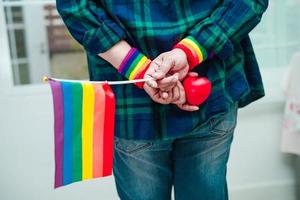 femme asiatique avec drapeau arc-en-ciel, droits des symboles lgbt et égalité des sexes, mois de la fierté lgbt en juin. photo