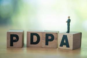 homme d'affaires miniature debout sur une cale en bois avec texte pdpa. pdpa acronyme loi sur la protection des données personnelles photo