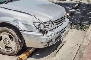 voiture endommagée à l'avant en raison d'un accident de voiture sur la route photo