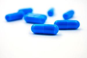 capsules bleues sur fond blanc photo