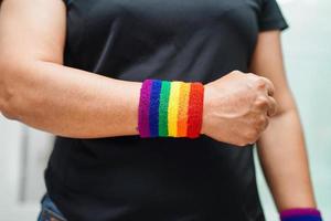 femme asiatique avec drapeau arc-en-ciel, droits des symboles lgbt et égalité des sexes, mois de la fierté lgbt en juin. photo