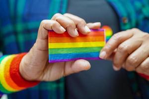 femme asiatique avec drapeau arc-en-ciel, droits des symboles lgbt et égalité des sexes, mois de la fierté lgbt en juin. photo