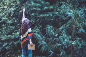 jeune femme se détendre pendant les vacances. voyagez dans la nature et écrivez une note heureuse de voir la beauté de la feuille de pin. étude de la nature. photo