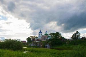 un village au bord de la rivière avec une herbe verte brillante et un beau ciel. photo