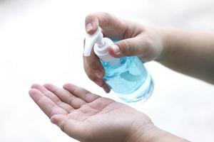 femme appuyant sur le gel d'alcool nettoyant les bactéries et les virus sur fond blanc. photo