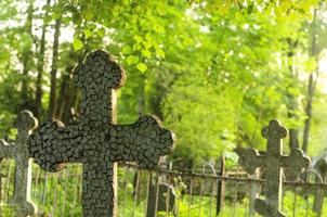 une croix sur la tombe et plusieurs croix plus loin sur le cimetière photo