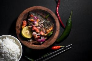 menu de poisson frit épicé avec bol de riz sur fond noir. photographie de cuisine asiatique. bon pour le menu et l'affiche du restaurant photo