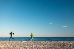 un enfant avec sa mère court le long de la plage photo