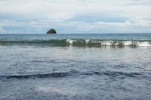 une petite île dans l'océan avec des vagues de la mer photo