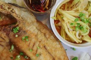 Le bar frit avec sauce de poisson et sauce épicée aux fruits de mer est un plat populaire pour les restaurants de fruits de mer qui proposent souvent un menu de bar frit avec sauce de poisson en raison de son goût délicieux. photo