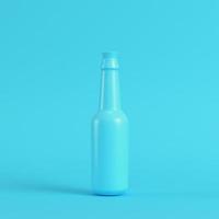 bouteille vierge avec bouchon sur fond bleu vif dans des tons pastel photo