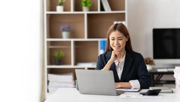 portrait d'une belle femme asiatique d'affaires souriante travaillant au bureau utiliser un ordinateur avec espace de copie. propriétaire d'entreprise personnes PME marketing en ligne indépendant e-commerce télémarketing, concept de travail à domicile photo