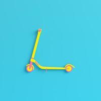 trottinette jaune sur fond bleu vif dans des tons pastel. notion de minimalisme photo