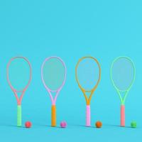 raquettes de tennis colorées avec des balles sur fond bleu vif dans des couleurs pastel. notion de minimalisme photo