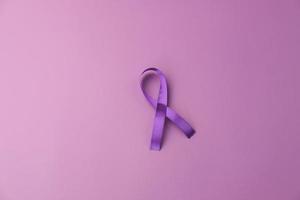 ruban violet comme symbole de la journée mondiale du cancer sur fond violet, espace de copie. photo