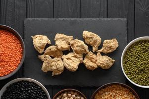 viande de soja et légumineuses, mise à plat aérienne tournée sur un fond de bois rustique foncé photo