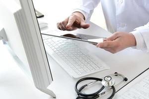 un médecin à l'aide d'une tablette numérique pour faire des notations
