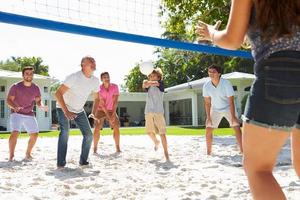 Famille multi génération masculine jouant au volley-ball dans le jardin photo