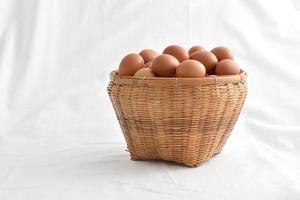 Oeufs dans le panier rempli isolé sur fond blanc photo