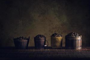 grains de café dans un récipient sur un plancher en bois et un vieux papier vintage vieilli ou une texture photo