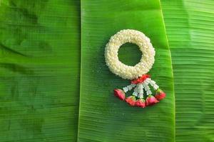 guirlande de jasmin traditionnel thaïlandais.symbole de la fête des mères en thaïlande sur une feuille de bananier photo