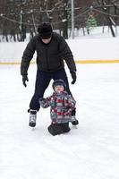 grand-père apprend à son petit-enfant à patiner photo