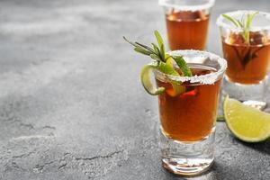 verre avec de l'alcool, du sel et de la chaux sur un fond de béton foncé. tequila cognac whisky. le concept de fête. mise au point sélective. espace de copie. photo