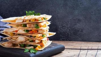tranches triangulaires d'une quesadilla mexicaine avec la sauce. le plat traditionnel du mexique est les tortillas farcies de viande et de légumes. espace de copie.