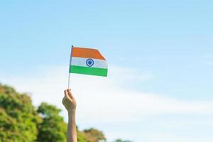 main tenant le drapeau de l'inde sur fond de ciel bleu. vacances du jour de la république indienne, joyeux jour de l'indépendance et concepts de gandhi jayanti photo