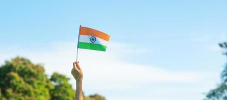 main tenant le drapeau de l'inde sur fond de ciel bleu. vacances du jour de la république indienne, joyeux jour de l'indépendance et concepts de gandhi jayanti photo
