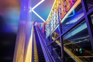 escalator avec lumière led à côté du thème de la lumière colorée au néon abstrait de la technologie. photo