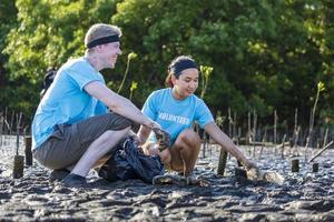 une équipe de jeunes et d'un groupe de travailleurs bénévoles de la diversité profite d'un travail social caritatif en plein air dans le cadre d'un projet de nettoyage des ordures dans la forêt de mangrove photo