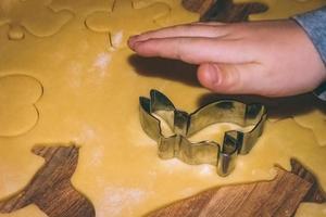 une main d'enfant sur une pâte à biscuits photo