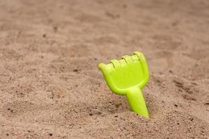 un râteau dans le sable sur la plage photo