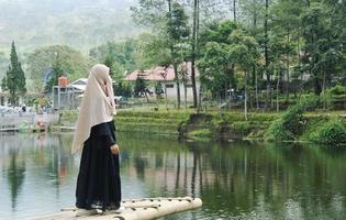 wonosobo, indonésie, 12 décembre 2019. bedakah , une fille profite de vacances sur le lac, elle est debout sur l'eau photo