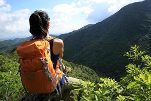 Backpacker femme profiter de la vue sur la falaise de pic de montagne