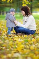 jeune maman avec son petit bébé dans le parc en automne photo