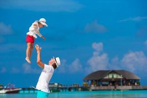 adorable petite fille et père heureux pendant les vacances à la plage tropicale photo
