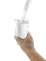 verre de lait sur les mains humaines. isolé sur fond blanc photo